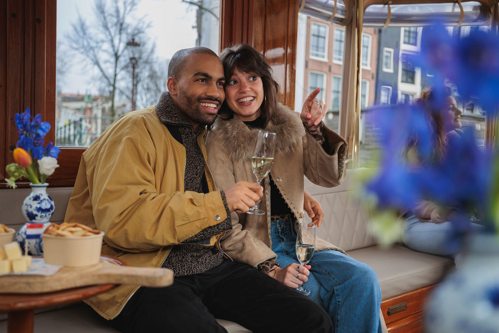 Young couple pointing at their nice view from their canal cruise tour